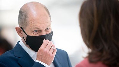 Foto: Olaf Scholz mit Mund-Nase-Bedeckung in einem Gespräch