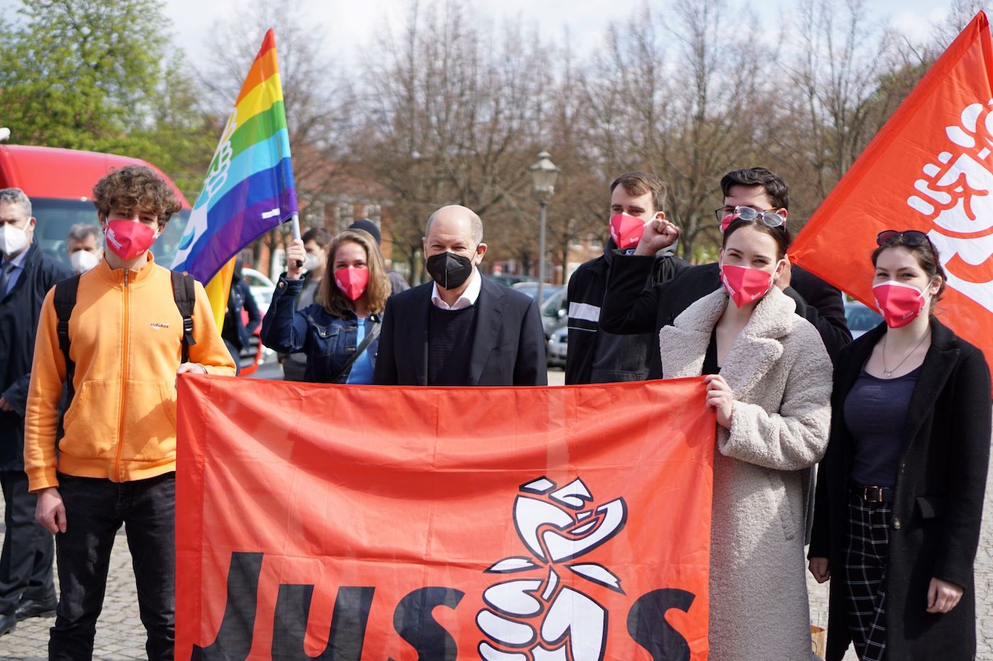 Auf der DGB Kundgebung auf dem Bassinplatz steht Olaf Scholz mit einigen Jusos, die eine große Jusos Flagge halten.