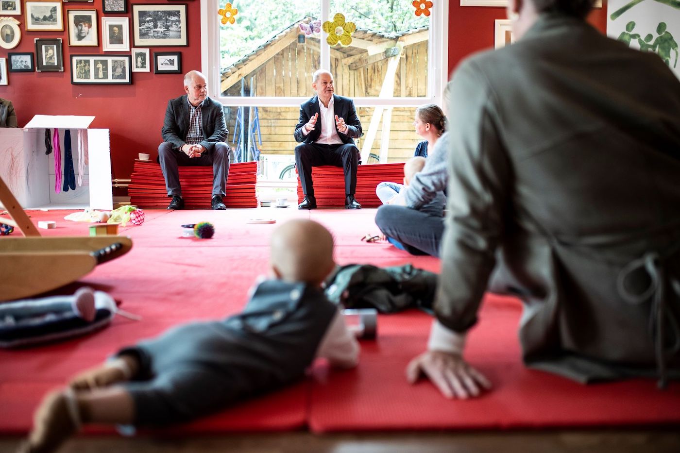 Im Mehrgenerartionenhaus Philantow: Olaf Scholz unterhält sich mit Eltern. Ein Baby krabbelt auf der Spielmatte.